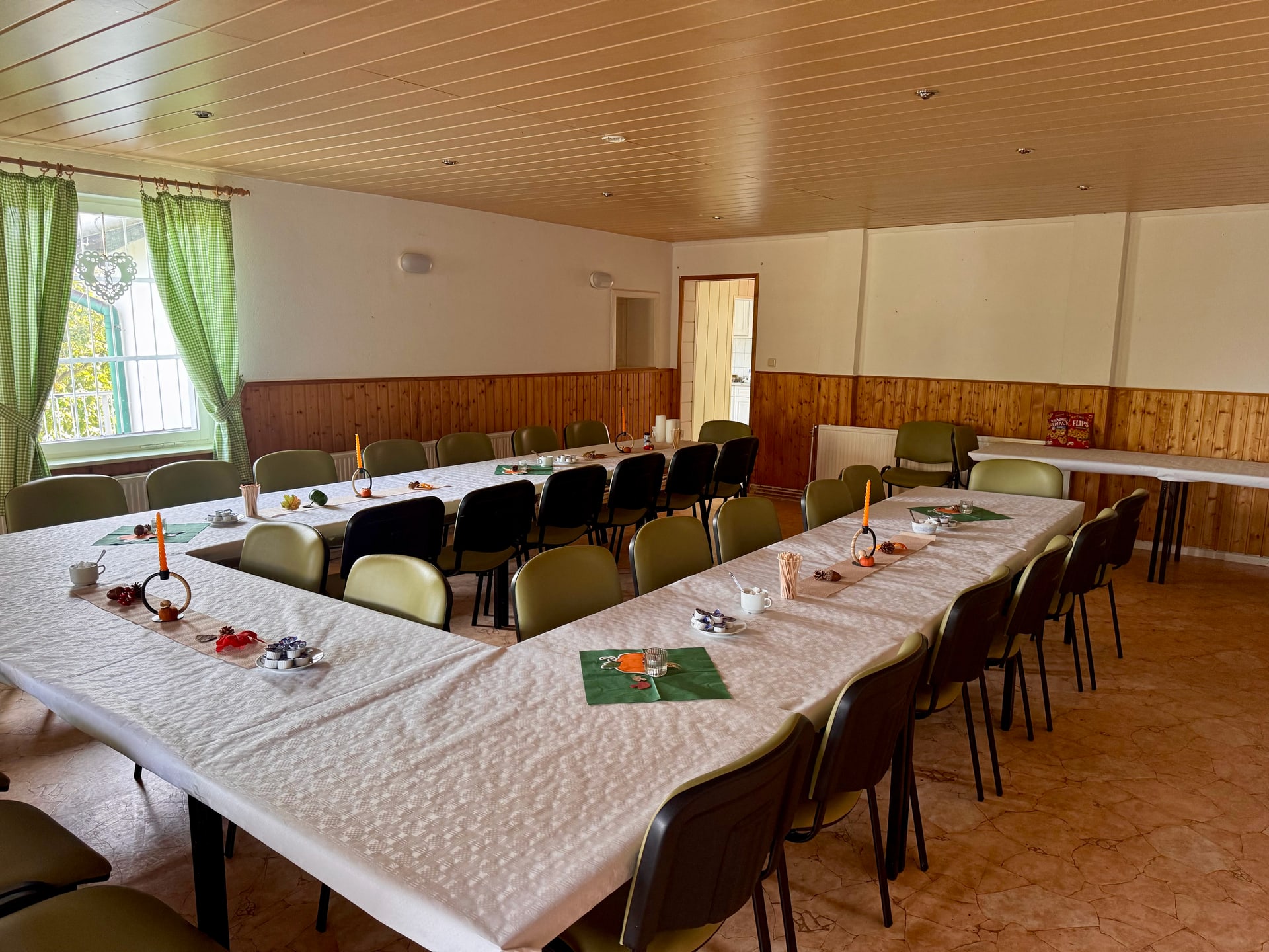 Innenraum des Vereinsheims mit gedeckten Tischen und Sitzplätzen